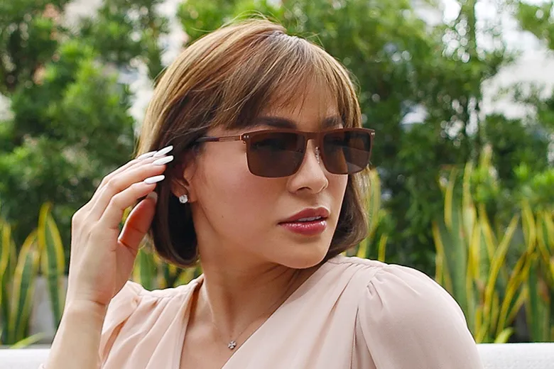 A woman wearing sunglasses with a nature background