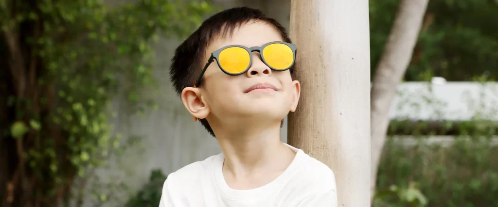 a kid wearing sunglasses - How to Prevent Eye Damage